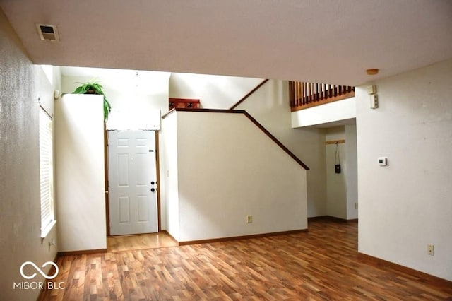 607 Deer Trail Dr, Indianapolis, IN 46217 - unfurnished living room with visible vents, baseboards, wood finished floors, and stairs