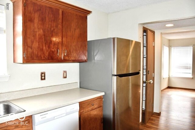 607 Deer Trail Dr, Indianapolis, IN 46217 - kitchen featuring baseboards, light countertops, freestanding refrigerator, white dishwasher, and wood finished floors