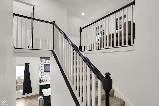 1818 Orleans St, Indianapolis, IN 46203 - staircase with visible vents, recessed lighting, wood finished floors, and a towering ceiling