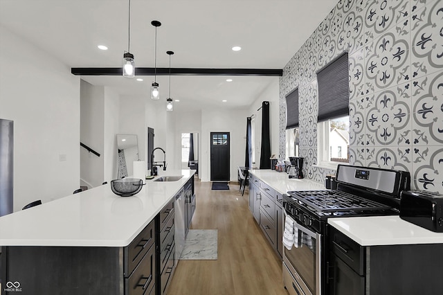 1818 Orleans St, Indianapolis, IN 46203 - kitchen with light wood-style floors, a sink, stainless steel gas range, and light countertops