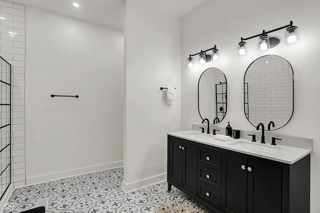 1818 Orleans St, Indianapolis, IN 46203 - bathroom featuring double vanity, baseboards, tiled shower, and a sink