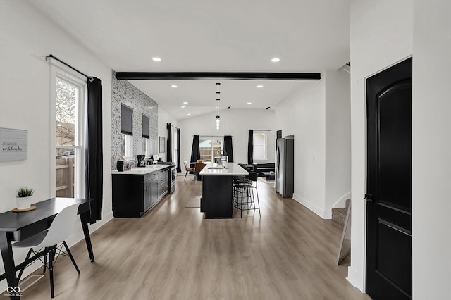 1818 Orleans St, Indianapolis, IN 46203 - kitchen with a kitchen breakfast bar, light countertops, baseboards, dark cabinetry, and light wood-style flooring