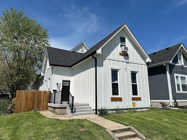 1818 Orleans St, Indianapolis, IN 46203 - modern inspired farmhouse with a shingled roof, a front lawn, board and batten siding, and fence