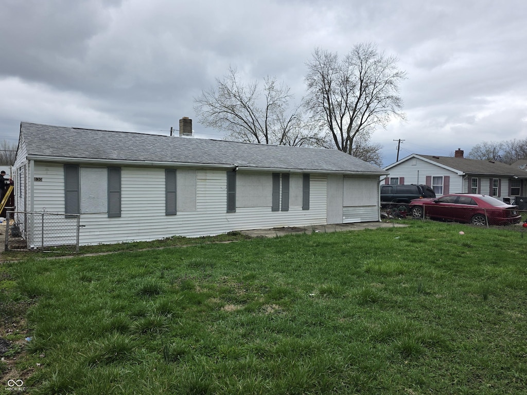 1830 S Chester Ave, Indianapolis, IN 46203 - exterior space with fence, a shingled roof, and a front lawn