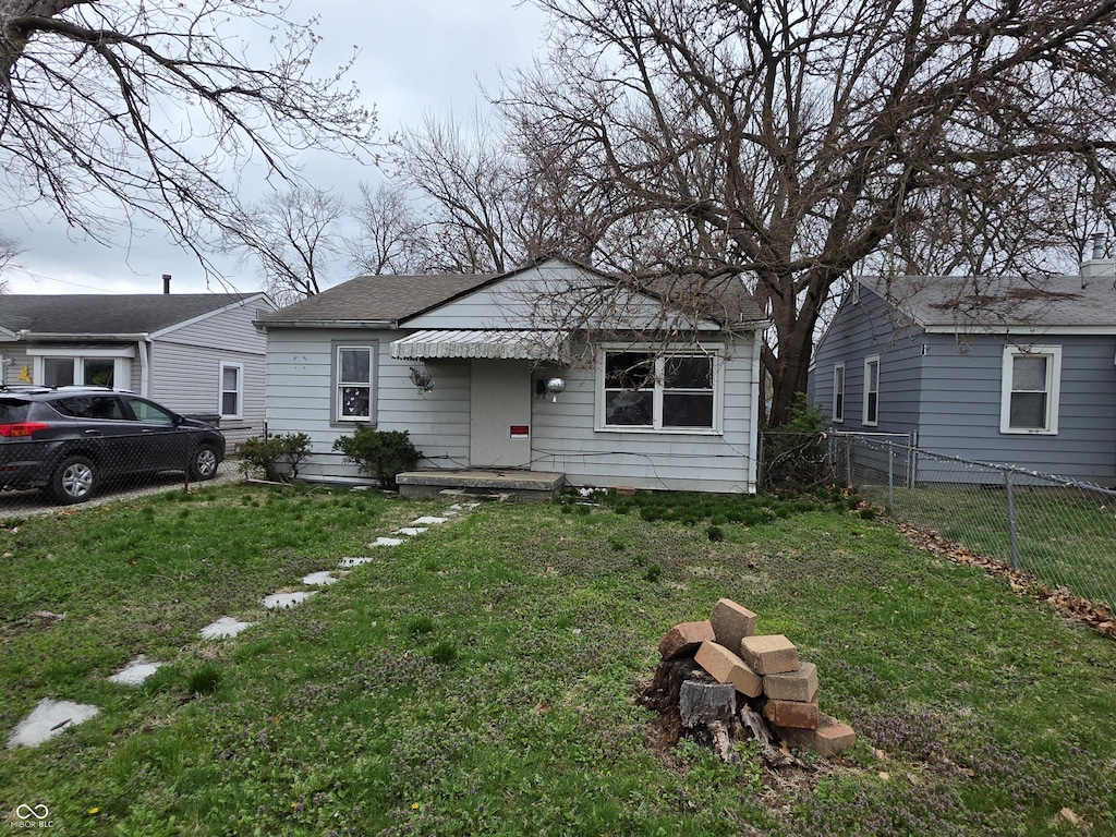 5842 Greenfield Ave, Indianapolis, IN 46219 - bungalow featuring a shingled roof, fence, and a front yard