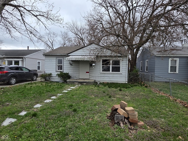 5842 Greenfield Ave, Indianapolis, IN 46219 - bungalow featuring a shingled roof, fence, and a front yard