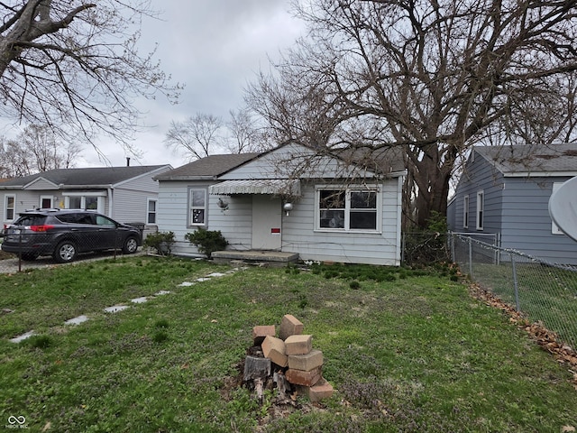 5842 Greenfield Ave, Indianapolis, IN 46219 - bungalow-style home with fence, roof with shingles, and a front lawn
