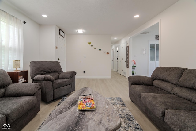 living room with recessed lighting, light wood-type flooring, and baseboards