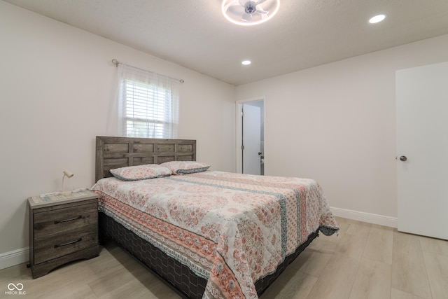 bedroom with baseboards, light wood finished floors, and recessed lighting