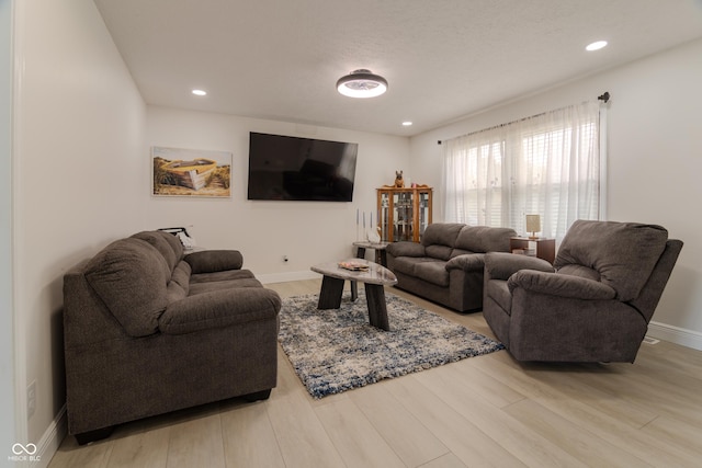 living room with baseboards, wood finished floors, and recessed lighting