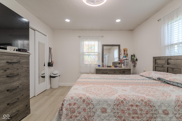 bedroom with recessed lighting, light wood-style floors, and baseboards