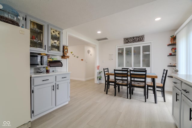 dining space with light wood finished floors, visible vents, and recessed lighting