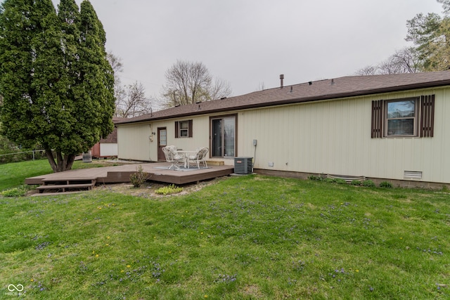 rear view of property featuring a lawn, fence, and a deck