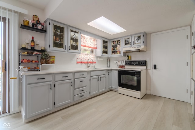 kitchen with open shelves, a sink, a skylight, range with electric cooktop, and under cabinet range hood