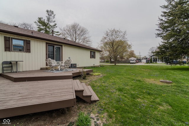 back of property with a yard and a deck