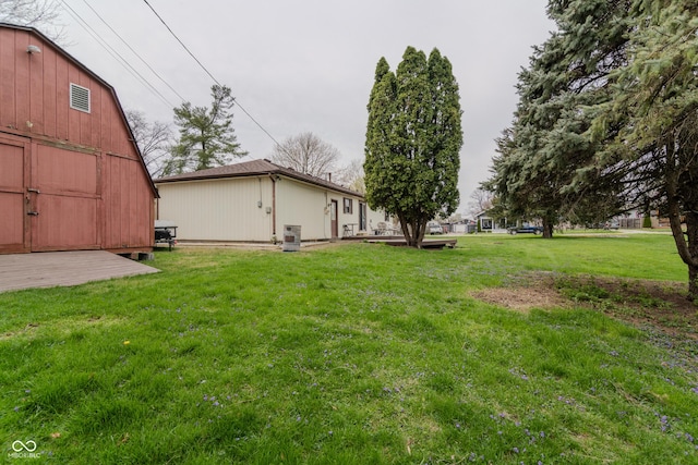 view of yard with an outdoor structure, a barn, and central AC unit