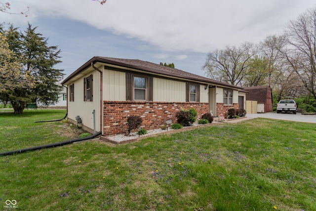 ranch-style home featuring brick siding and a front lawn