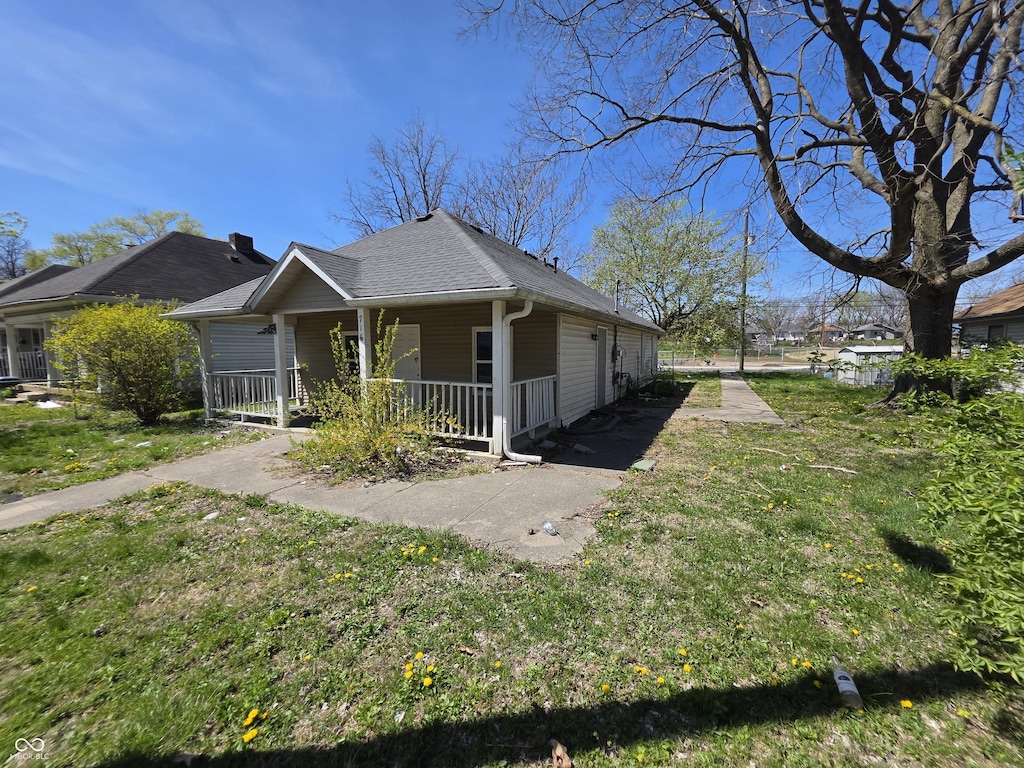 716 Lynn St, Indianapolis, IN 46222 - view of front of property with a porch, a front lawn, and roof with shingles