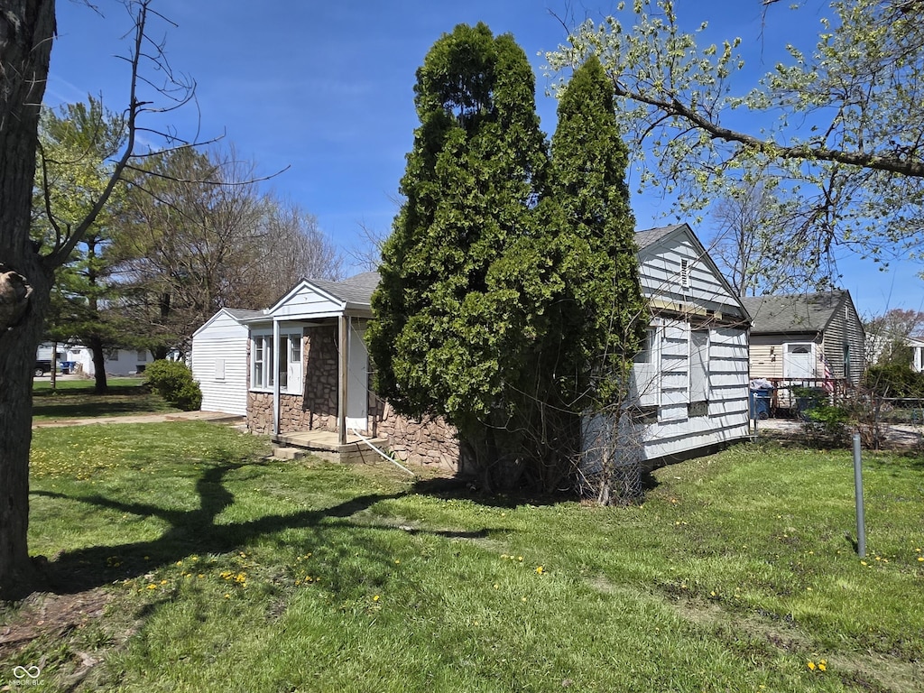 2950 Denison St, Indianapolis, IN 46241 - view of side of home with an outbuilding, a yard, and stone siding