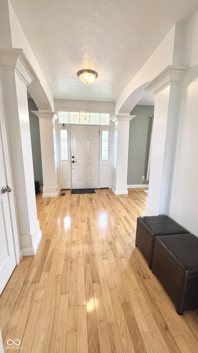 3724 Jonathan Rdg, Columbus, IN 47201 - entrance foyer with decorative columns, arched walkways, light wood-type flooring, and a textured ceiling