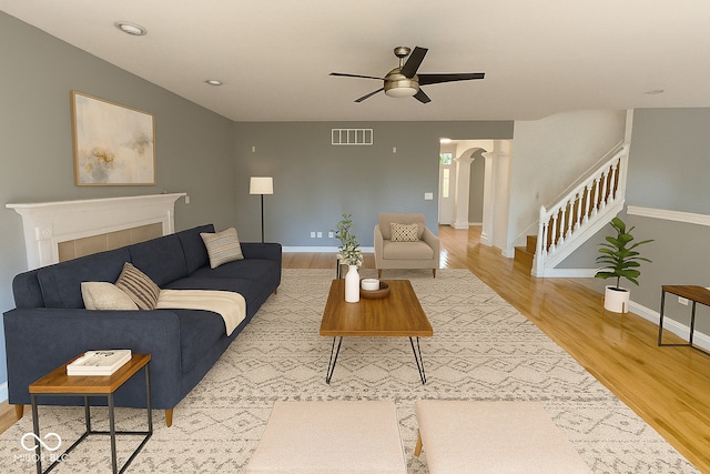 3724 Jonathan Rdg, Columbus, IN 47201 - living room with ceiling fan, arched walkways, light wood finished floors, and stairway