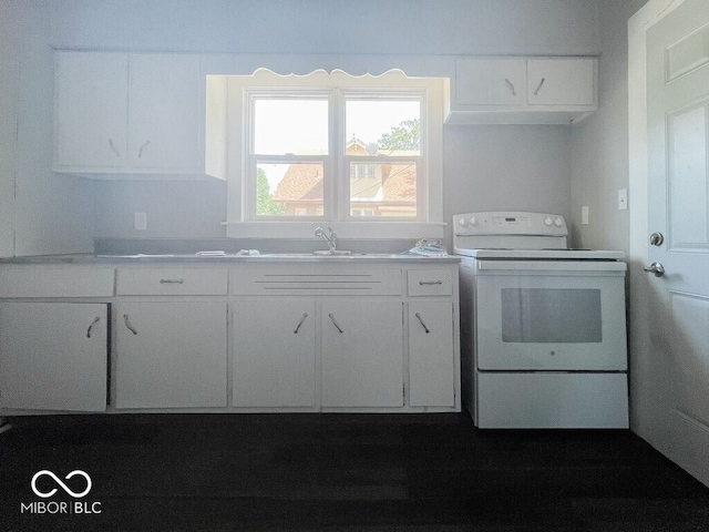 312 S Gharkey St, Muncie, IN 47305 - kitchen with white range with electric cooktop, white cabinets, a sink, and light countertops
