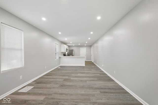 unfurnished living room with recessed lighting, baseboards, visible vents, and light wood-style flooring