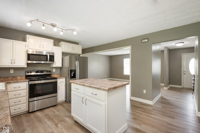 4786 N Mill Ct, Greenfield, IN 46140 - kitchen featuring appliances with stainless steel finishes, white cabinetry, a textured ceiling, light wood finished floors, and baseboards