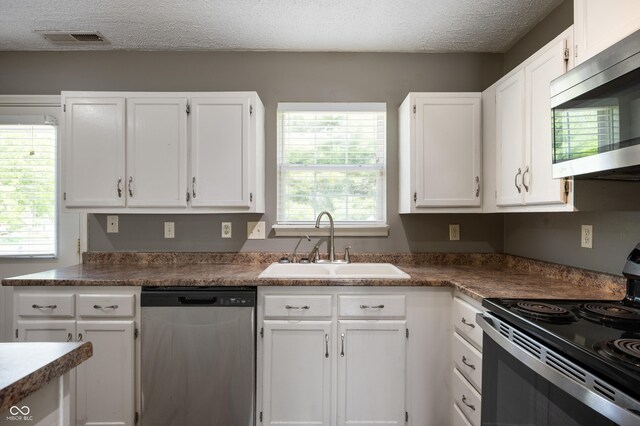 4786 N Mill Ct, Greenfield, IN 46140 - kitchen with appliances with stainless steel finishes, a sink, white cabinetry, a textured ceiling, and plenty of natural light