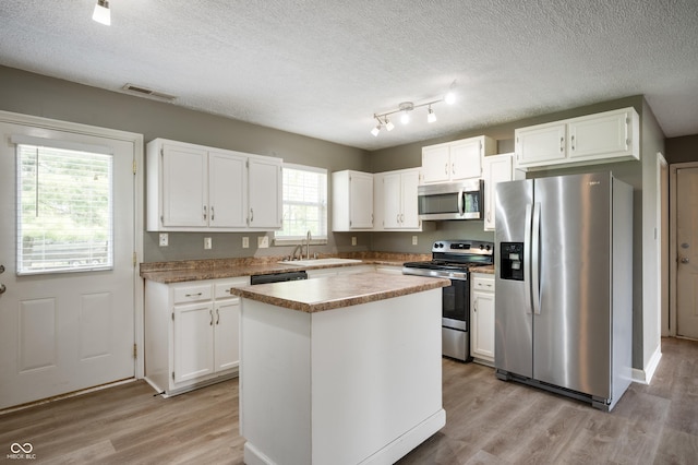 4786 N Mill Ct, Greenfield, IN 46140 - kitchen featuring stainless steel appliances, a sink, light wood-type flooring, white cabinetry, and a textured ceiling