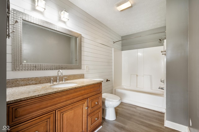 4786 N Mill Ct, Greenfield, IN 46140 - full bathroom featuring wood finished floors, toilet, vanity, a textured ceiling, and shower / washtub combination