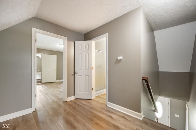 4786 N Mill Ct, Greenfield, IN 46140 - hall with an upstairs landing, a textured ceiling, light wood finished floors, baseboards, and lofted ceiling