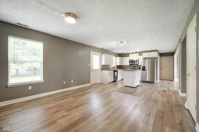 4786 N Mill Ct, Greenfield, IN 46140 - kitchen with stainless steel appliances, white cabinetry, baseboards, a textured ceiling, and light wood-type flooring