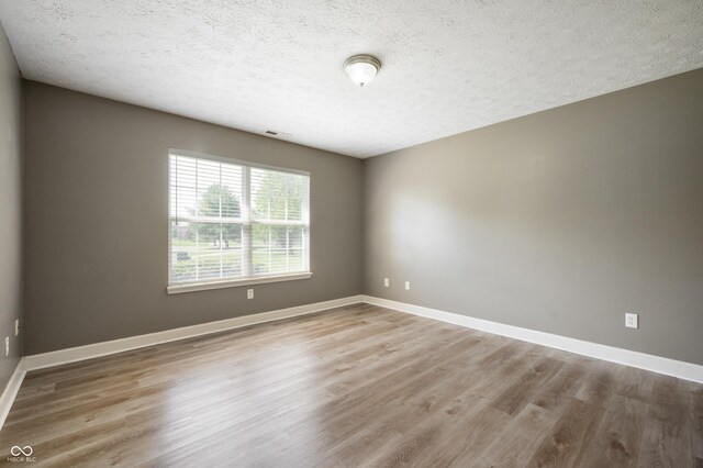 4786 N Mill Ct, Greenfield, IN 46140 - unfurnished room with wood finished floors, baseboards, and a textured ceiling