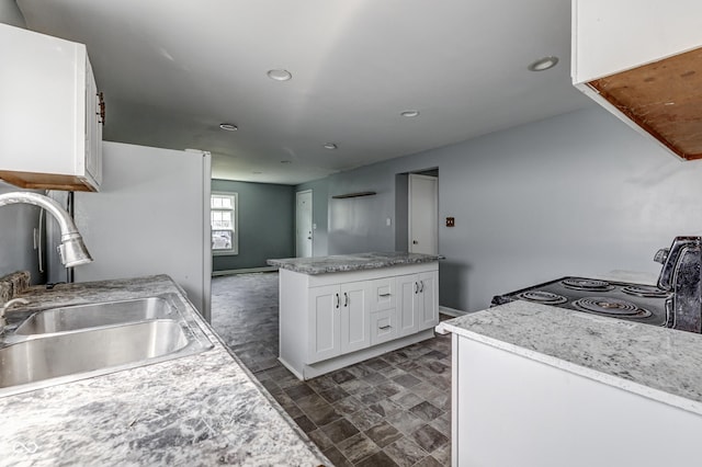 kitchen with white cabinets, baseboards, a sink, and black electric range oven