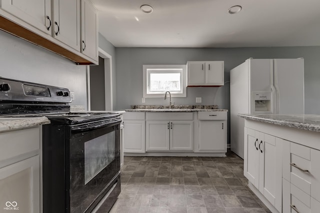 kitchen featuring light stone counters, a sink, black electric range, white fridge with ice dispenser, and white cabinetry