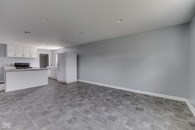 unfurnished living room with baseboards and recessed lighting