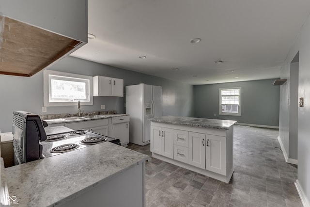 kitchen featuring white cabinets, white refrigerator with ice dispenser, a sink, and electric range