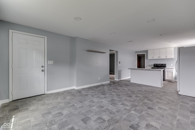 unfurnished living room featuring recessed lighting and baseboards