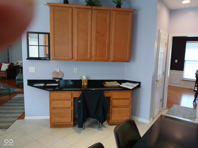 5983 Clearview Dr, Carmel, IN 46033 - kitchen featuring brown cabinets, built in study area, dark countertops, and baseboards
