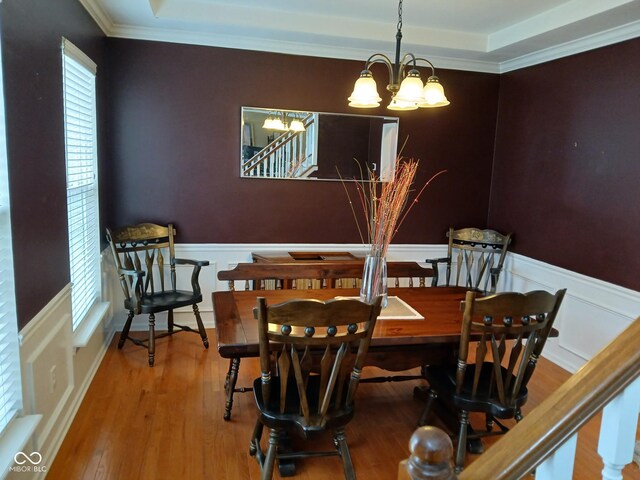 5983 Clearview Dr, Carmel, IN 46033 - dining area with an inviting chandelier, crown molding, a wainscoted wall, stairs, and wood finished floors