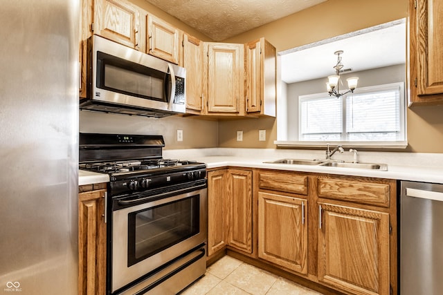 kitchen featuring light countertops, a sink, a chandelier, and appliances with stainless steel finishes