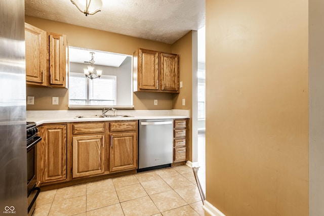 kitchen featuring light countertops, an inviting chandelier, appliances with stainless steel finishes, and a sink