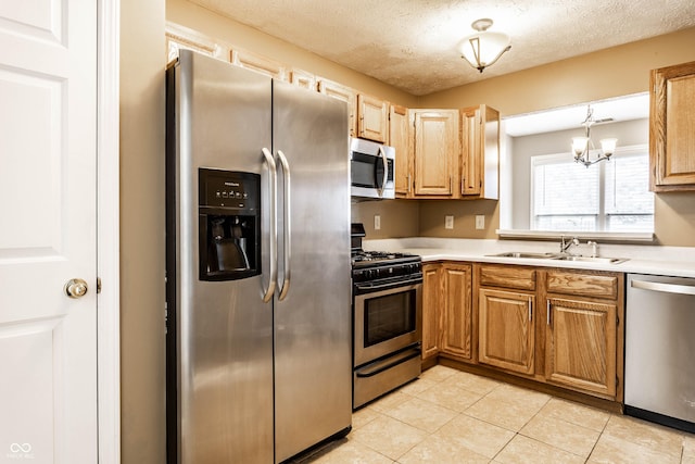 kitchen featuring light countertops, appliances with stainless steel finishes, light tile patterned floors, and a sink