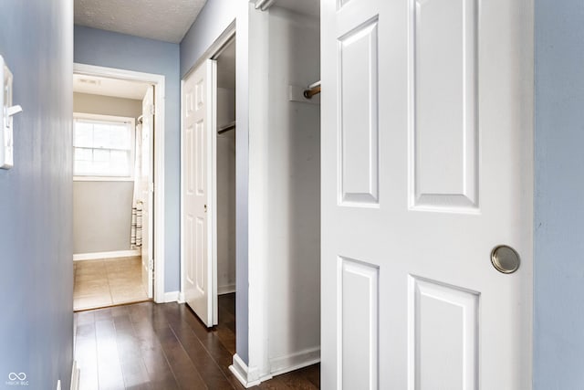 hallway with dark wood finished floors and baseboards