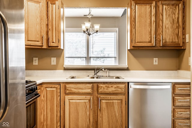 kitchen with stainless steel appliances, light countertops, a sink, and a notable chandelier
