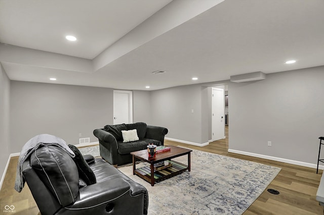 living room with visible vents, wood finished floors, and baseboards