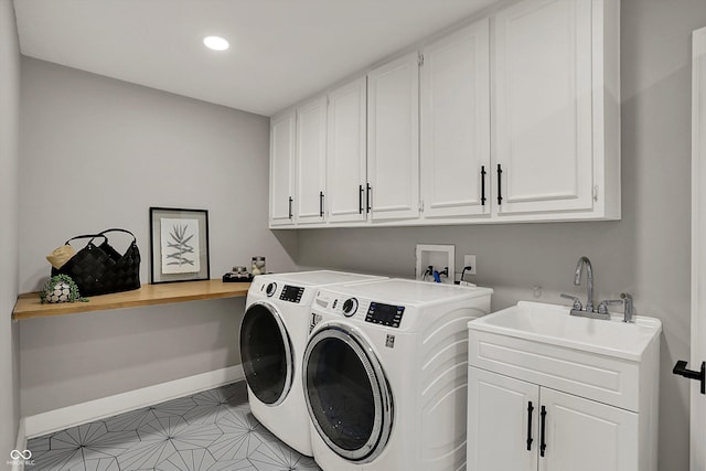 laundry room with a sink, washer and dryer, cabinet space, baseboards, and recessed lighting