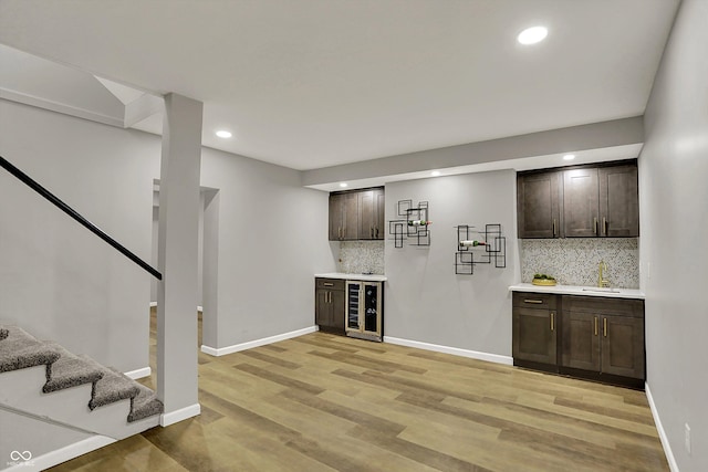 bar with tasteful backsplash, stairs, beverage cooler, indoor wet bar, and recessed lighting