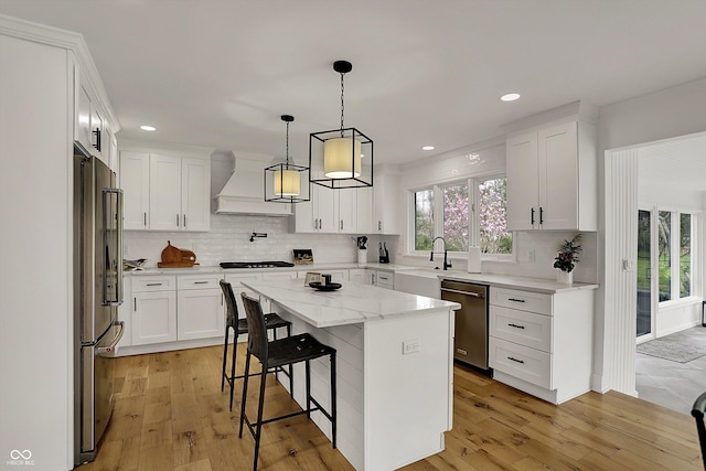 kitchen featuring stainless steel appliances, a sink, custom range hood, and tasteful backsplash